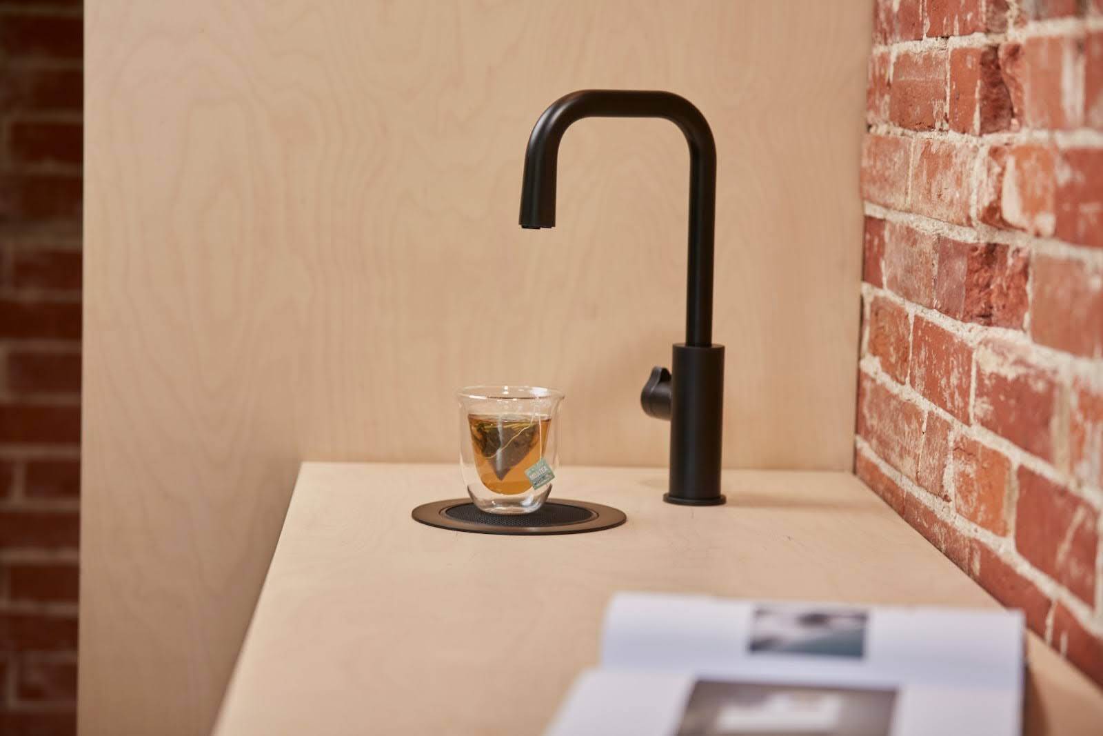 A matt black Zip tap in a industrial and modern office kitchen