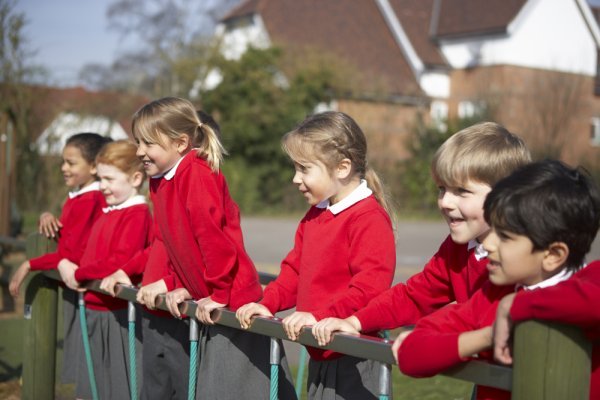 Children learning in an lesson being taught on the playground.