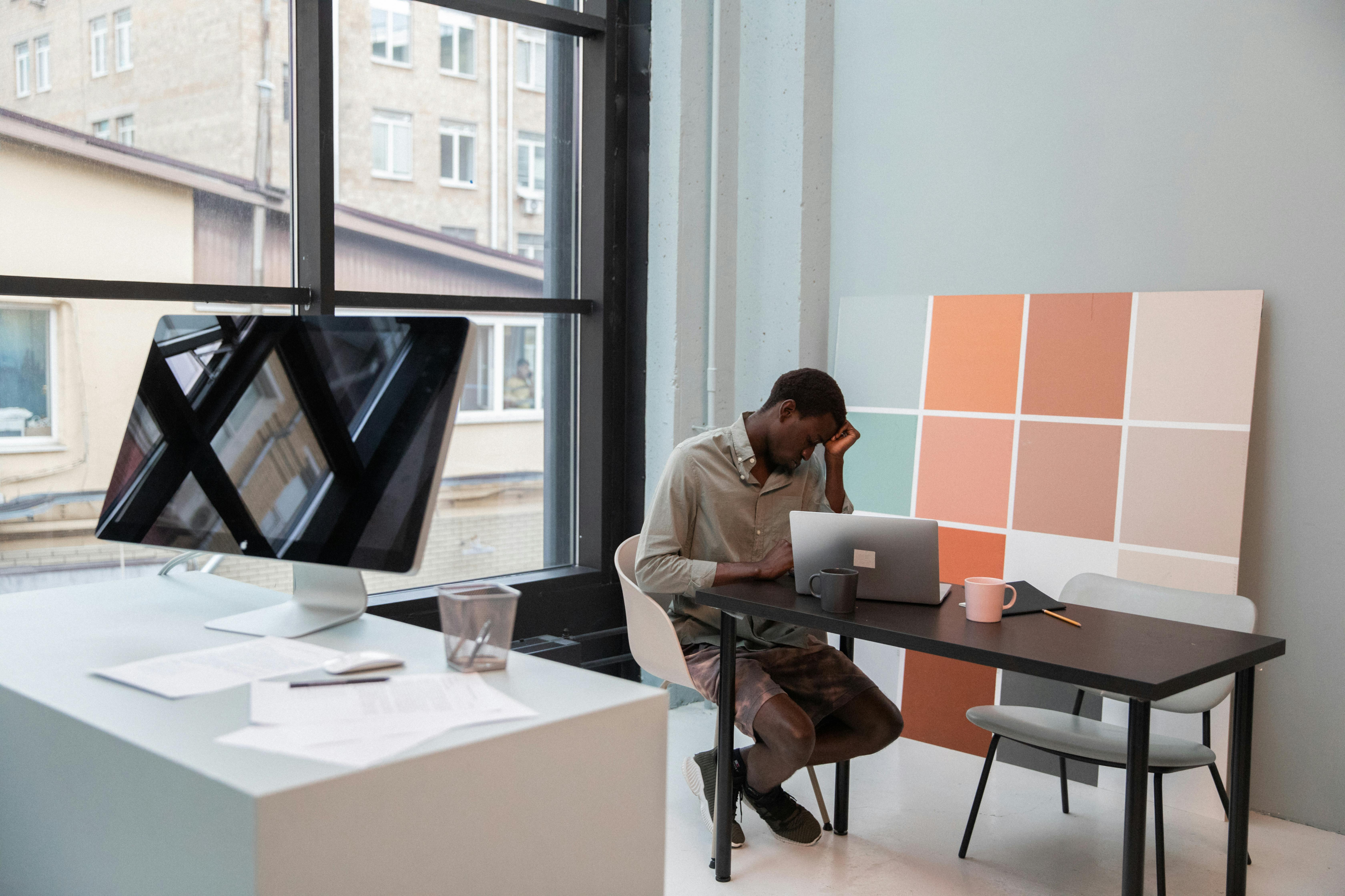 A quiet area of an office where a single employee is working at a desk.