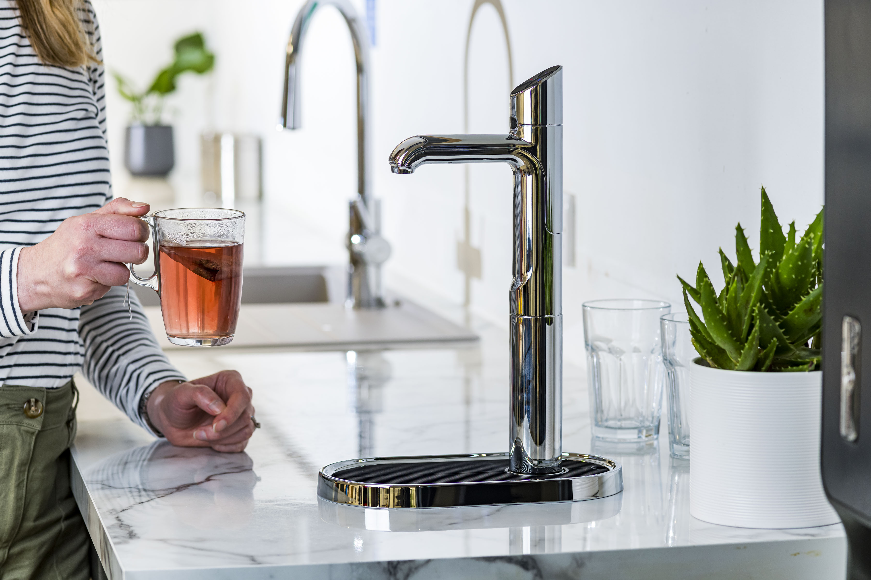 A zip tap in an office with an employee and a cup of tea