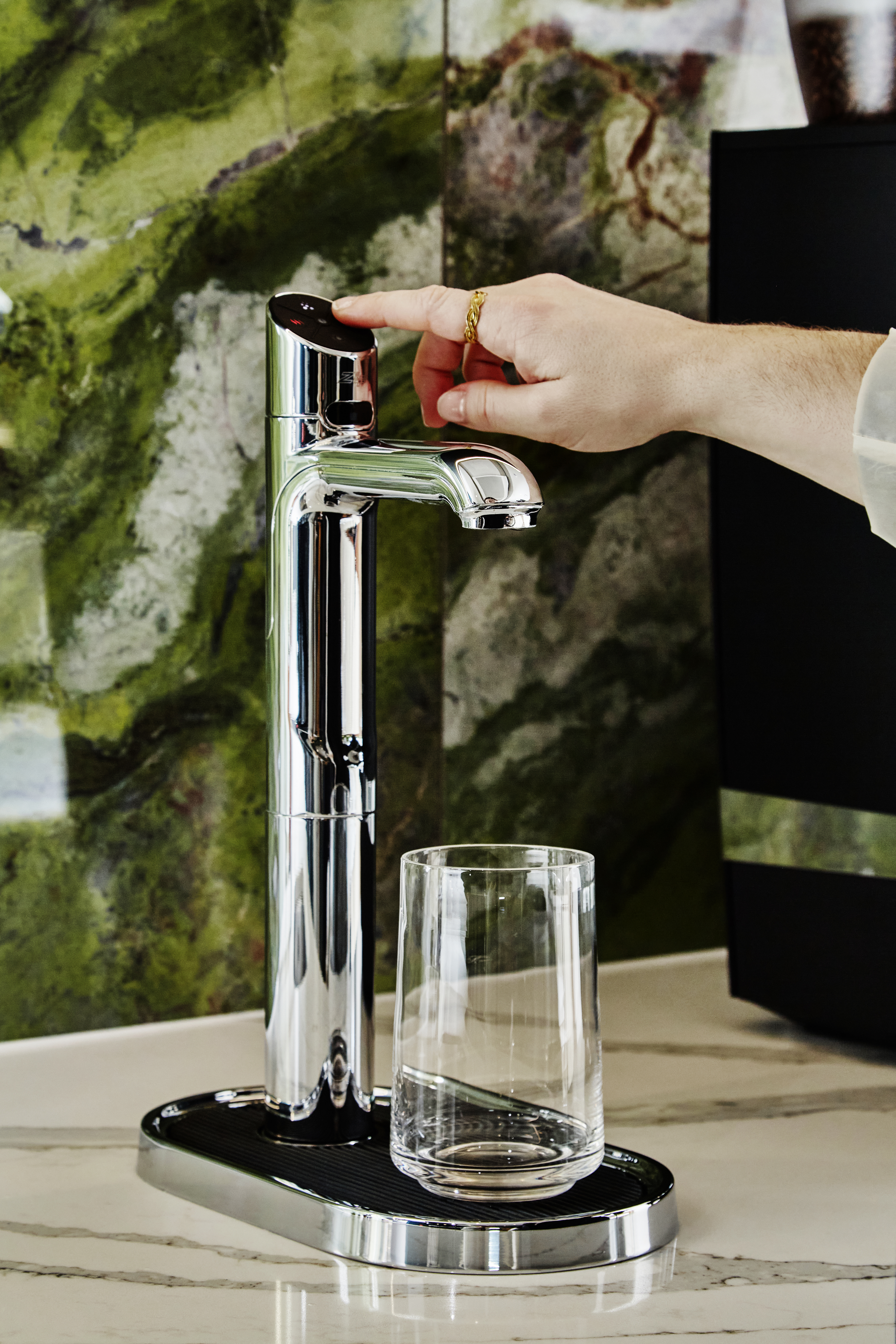 A Zip HydroTap in a smart office space with green design elements in the background.
