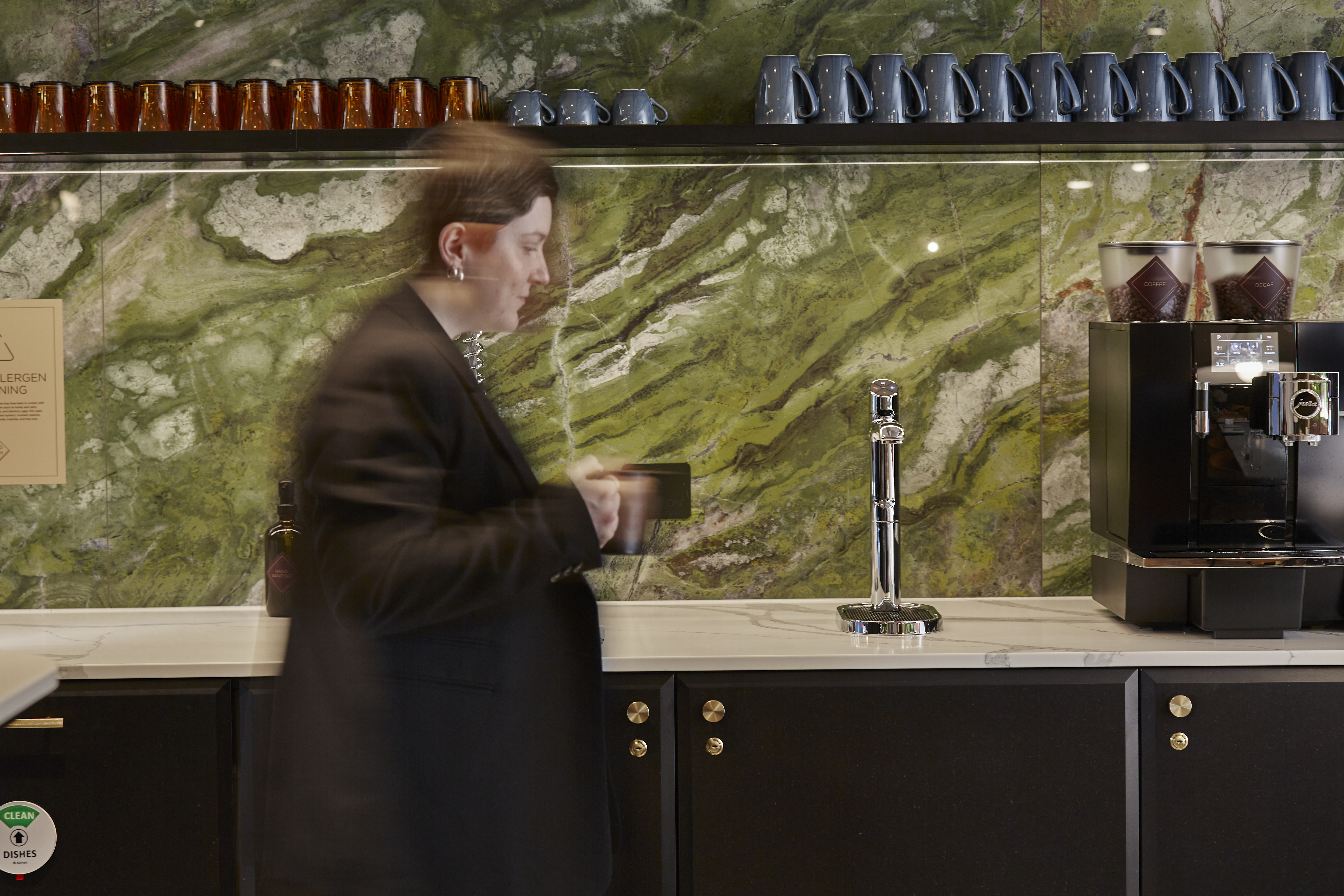 an office worker walking in front of a Zip tap and coffee machine