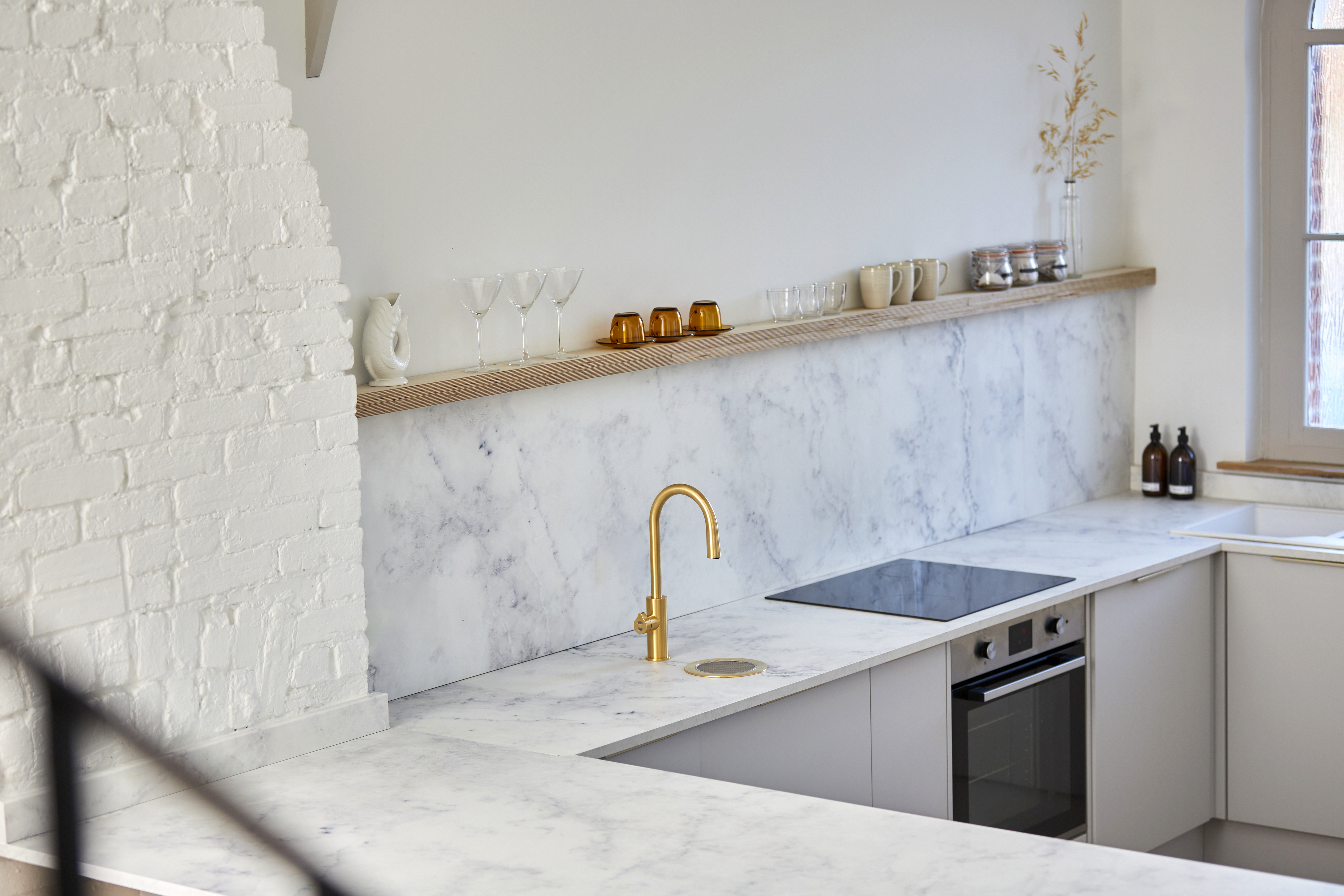 A white, spacious kitchen with a gold all-in-one HydroTap.