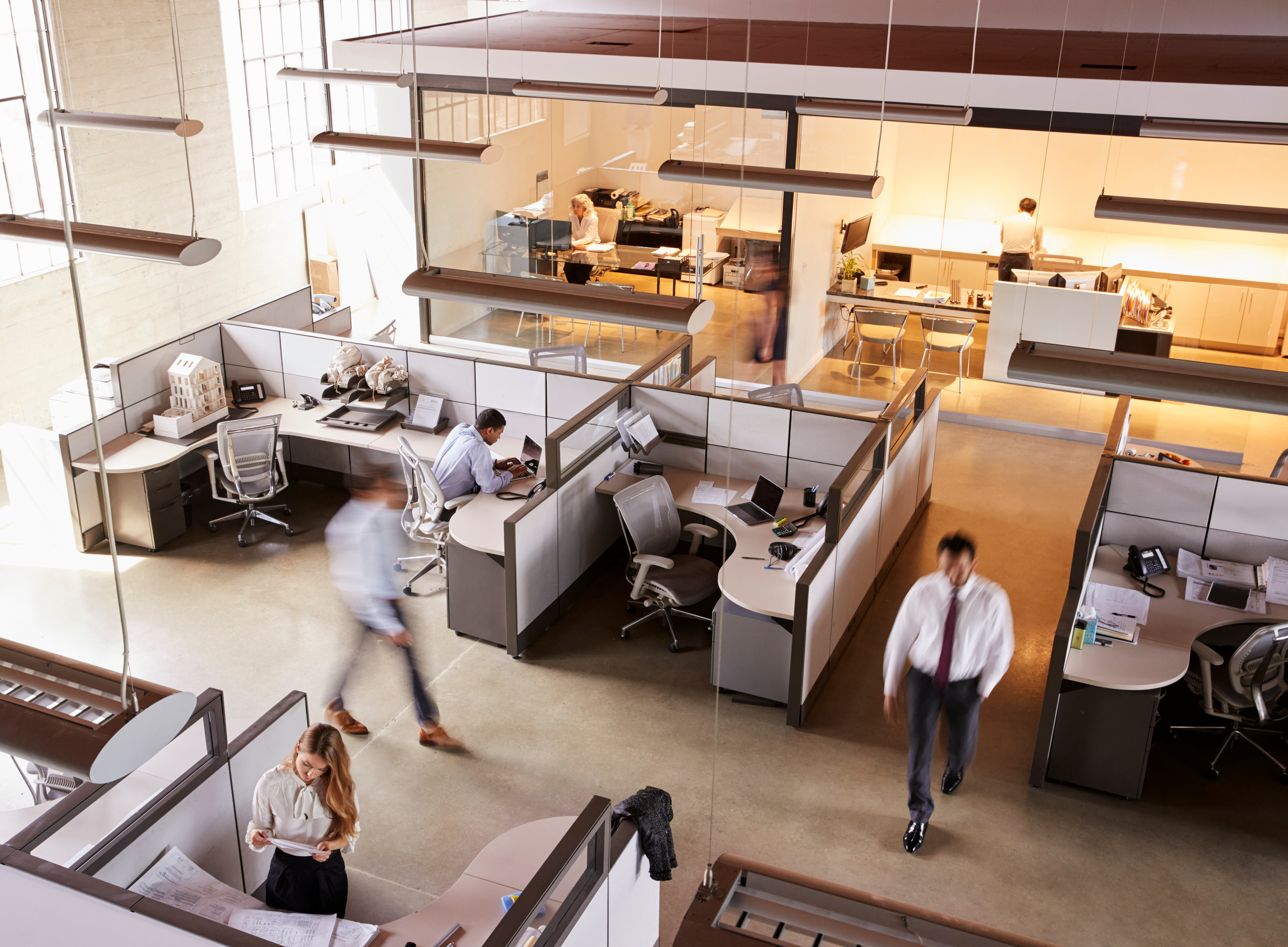 A busy office space with people walking or working at their desks