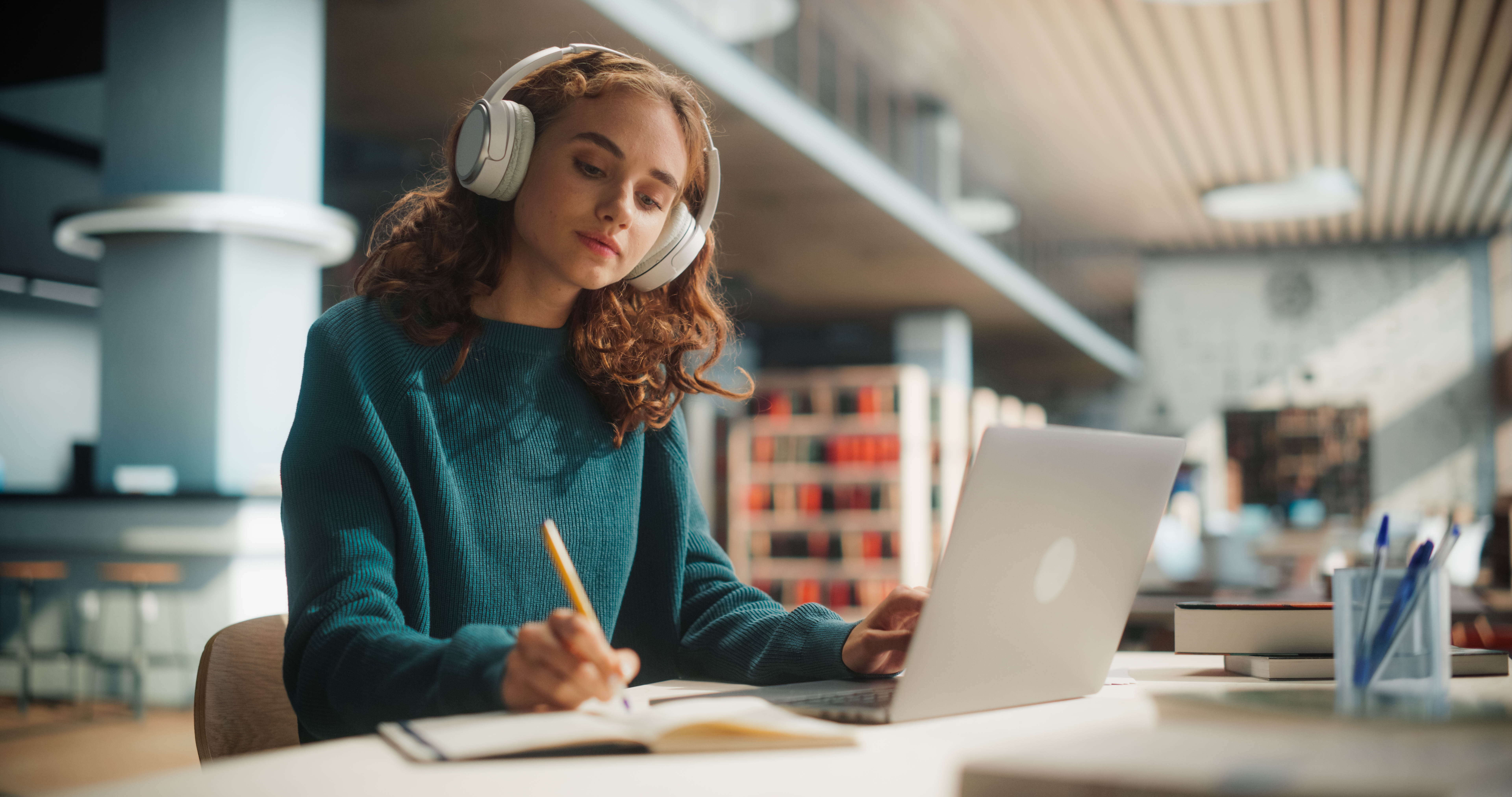 Student working at a laptop in a library